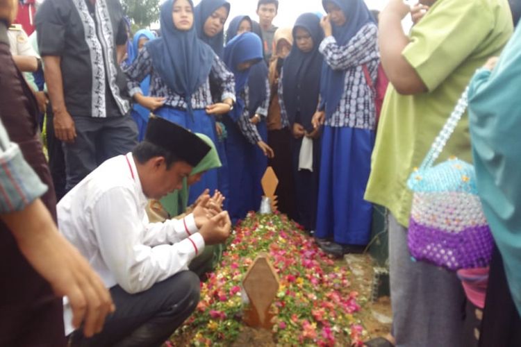 Pihak keluarga, guru dan siswa SMAN 14 Pekanbaru berdoa usai pemakaman jenazah Yanitra, seorang siswa yang tewas akibat tembok sekolah dasar roboh di Jalan Abidin, Kelurahan Air Dingin, Kecamatan Bukit Raya, Pekanbaru, Riau, Rabu (14/11/2018).