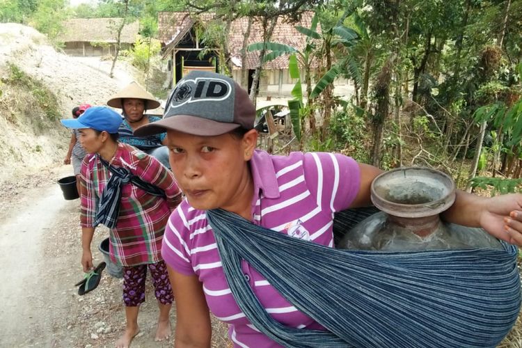 Sejumlah warga Desa Nglinduk dan Desa Suwatu, Kecamatan Gabus, Kabupaten Grobogan, Jawa Tengah mengambil air dari belik di sungai setempat, Sabtu (6/10/2018).?