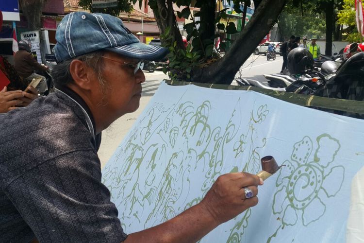 Nampak salah satu warga membatik kain putih pada acara mBatik bareng pada Napak Budaya Samanhoedi di Jalan KH Samanhoedi, Sondakan, Kecamatan Laweyan, Kota Solo, Kamis ( 2/11/2017) siang.