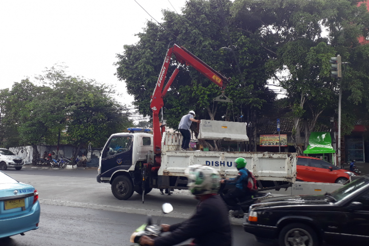 Petugas Dinas Perhubungan DKI Jakarta mengangkut beton movement concrete barrier (MCB) di simpang Mampang Prapatan menyusul diberhentikan uji coba penutupan tiga simpang di Jalan Mampang Prapatan, Jakarta Selatan, Minggu (20/5/2018).