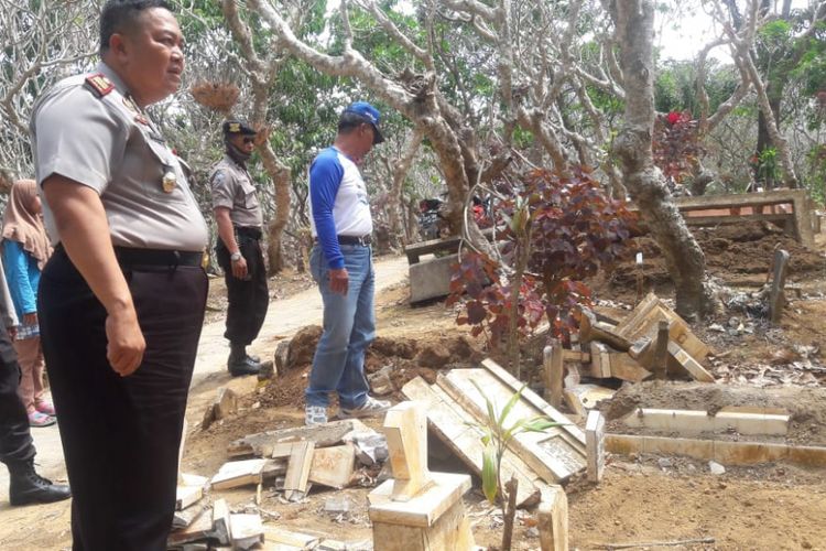 Polisi mendatangi makam yang rusak di Desa Pait, Kecamatan Kasembon, Kabupaten Malang.