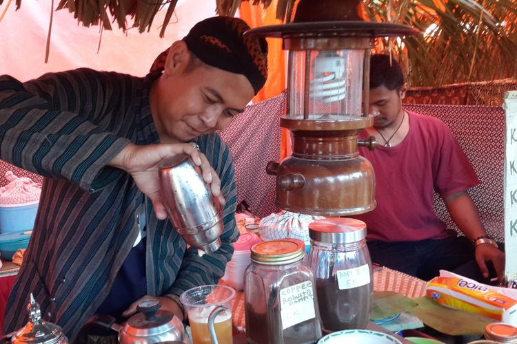 Arief Puji Prasetyo salah satu penjual bir jawa saat menyajikan bir jawa untuk pelanggannya di Festival Lawang Kota Tua, Kamis (27/9/2018)