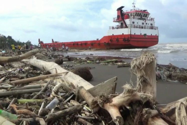 Sampah kayu gelondongan berserakan di sepanjang bibir pantai di Makassar pasca banjir Dan tanah longsor yang melanda sebagian wilayah di Sulsel. 