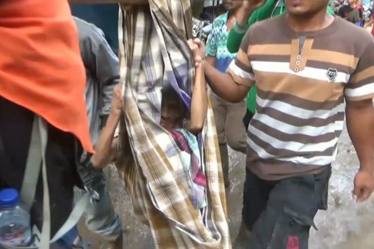 Nenek Hartati (64) tengah dievakuasi menggunakan sarung dan bambu oleh relawan lantaran kondisinya yang lemas akibat kelaparan selama berhari hari dalam bencana longsor yang melanda Kabupaten Gowa, Sulawesi Selatan, Senin (28/1/2019).