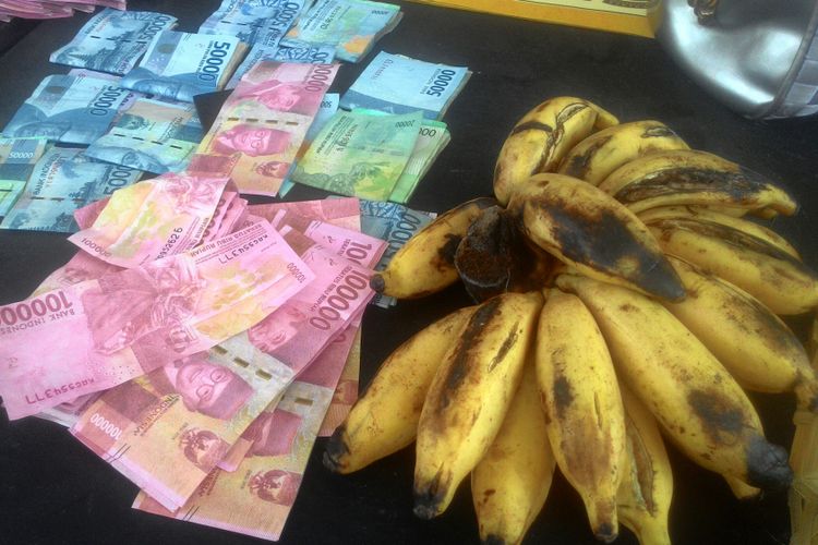 Seorang penjual pisang di Pasar Jagalan di Banjaroya, Kalibawang, Kulon Progo, DIY, menjadi korban peredaran uang palsu, Selasa (26/2/2019). Satu tandan pisang seharga Rp 10.000 ditukar dengan uang palsu Rp 100.000. Mbah Rupi, 70 tahun, pedagang pisang itu, pasrah karena kecerobohannya itu.  