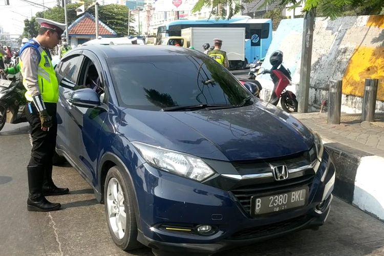 Pengendara mobil telepon kerabatnya agar tidak ditilang saat langgar ganjil genap di Jalan Gunung Sahari, Senin (9/9/2019).