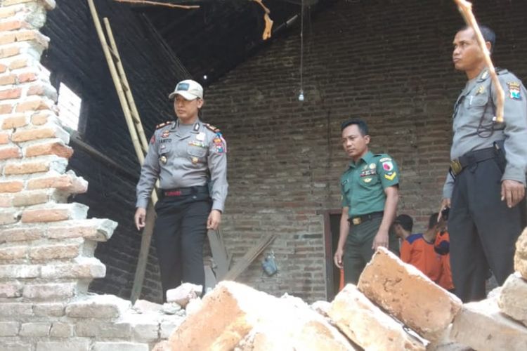 Kapolsek Tempurejo, AKP Suhartanto, melihat rumah warga yang rusak diguncang gempa Situbondo, Kamis (11/10/2018).