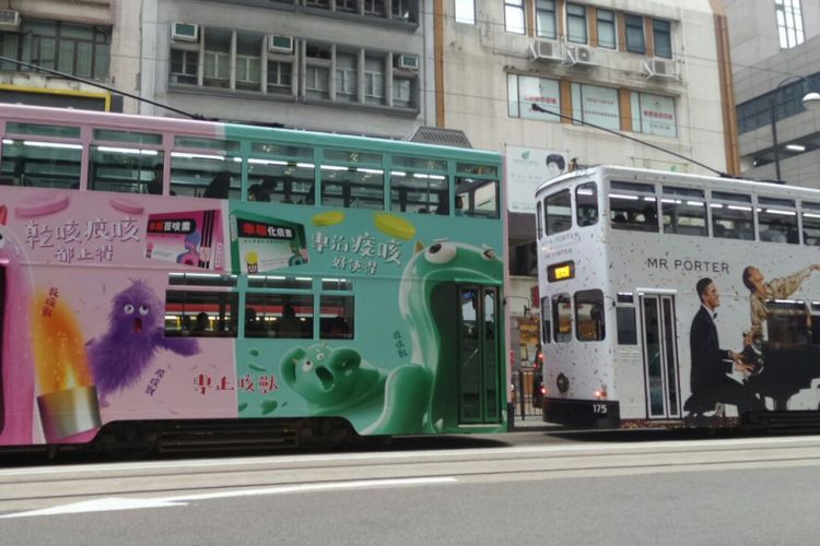 Beberapa unit tram sedang berhenti di halte untuk mengangkut atau menurunkan penumpang di Hongkong.