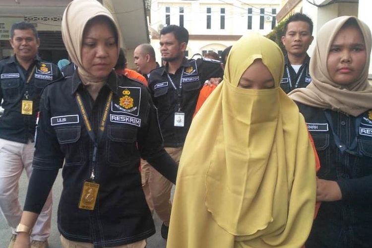 Polisi membawa NA (21) salah satu tersangka dalam kasus penyebaran berita bohong di Mapolres Lhokseumawe, Aceh, Rabu (17/7/2019)