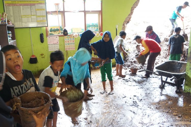 Guru dan para siswa kerja bakti membersihkan lumpur yang menjebol dinding kelas MI Nahdlatul Thullaab Senin (26/11/2018)  