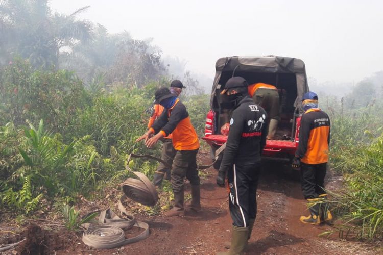 Petugas gabungan Manggala Agni Dumai berupaya melakukan pendinginan kebakaran lahan yang terjadi di Dumai