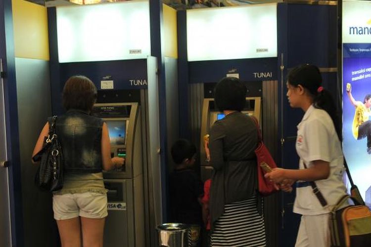 Pengambilan uang tunai di Anjungan Tunai Mandiri (ATM) Bank Mandiri, Jakarta