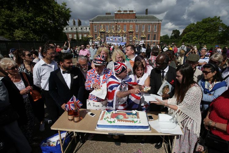 John Loughrey (tengah) membagikan irisan kue yang dihias dengan gambar Putri Diana, kepada anggota warga London yang berkumpul di luar gerbang Istana Kensington, Kamis (31/8/2017).  