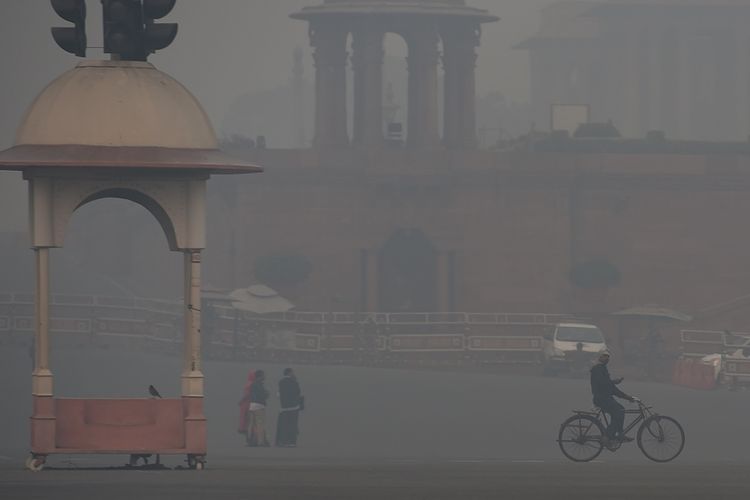 Warga beraktivitas di tengah kota Delhi, India yang tertutup kabut asap tebal yang berbahaya, Kamis (8/11/2018).
