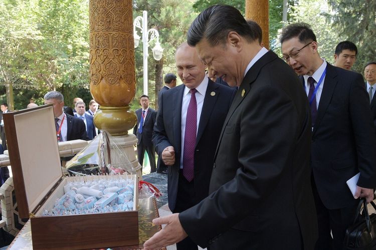 Presiden China Xi Jinping (dua dari kanan) melihat sekotak es krim, yang diberikan oleh Presiden Rusia Vladimir Putin (tiga dari kanan) sebagai kado ulang tahun, di Dushanbe, Tajikistan, Sabtu (15/6/2019).