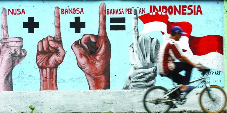Pengendara sepeda melintasi mural yang mengobarkan semangat persatuan dan kesatuan di Jalan Dinoyo Surabaya, Jawa Timur, Senin (27/10/2008).