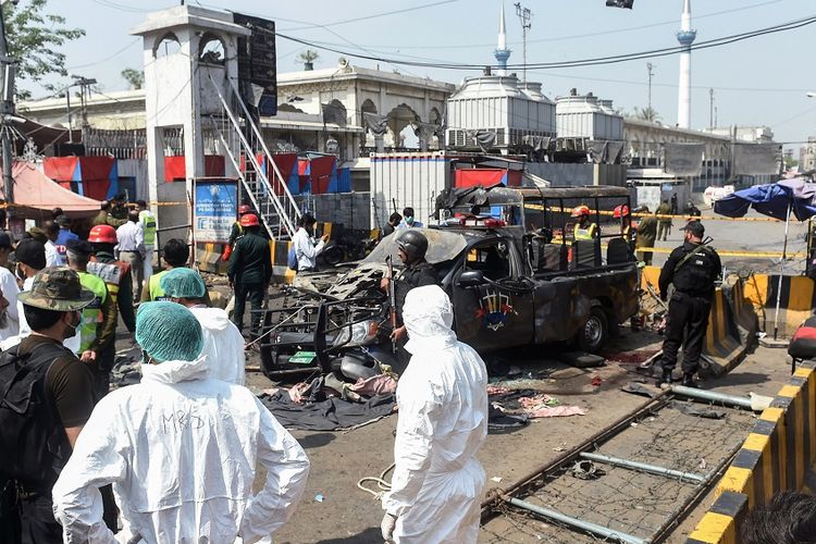 Petugas keamanan dan tim penyelidik berada di lokasi ledakan di luar kuil sufi Data Darbar di kota Lahore, Pakistan, Rabu (8/5/2019).