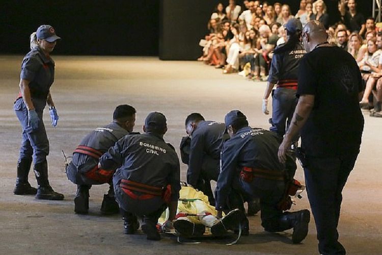Petugas medis berusaha memberikan pertolongan dan mengembalikan kesadaran model Tales Soares (26) yang mendadak ambruk saat memperagakan busana di Sao Paulo, Brasil.