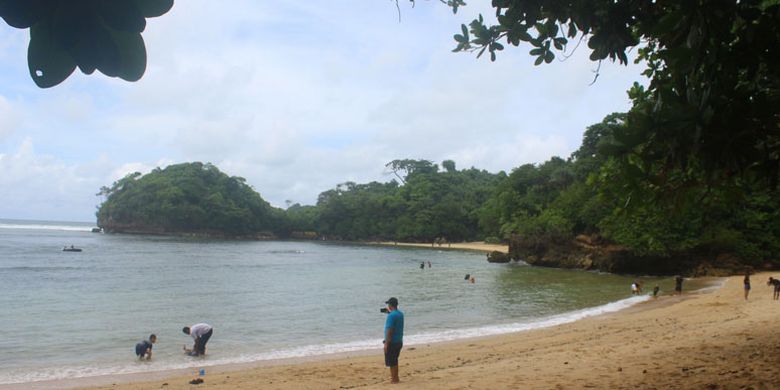 Sejumlah wisatawan saat mandi dan bermain di Pantai Banyu Meneng yang ada di dalam kawasan hutan lindung Kondang Merak, Kecamatan Bantur, Kabupaten Malang bagian selatan, Minggu (31/12/2017). Pantai tersebut diberi nama Banyu Meneng karena airnya yang tenang.