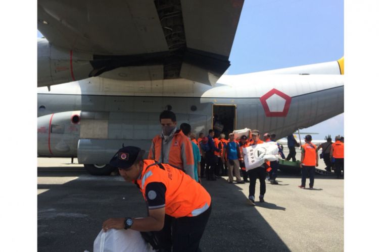 Para petugas satgas sedanh mengeluarkan barang logistik, Bandara Mutiara Sis Al Jufri Palu, Rabu (3/10/2018).