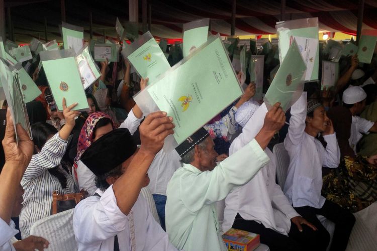 Warga memperlihatkan sertifikat tanah yang diterima saat penyerahan oleh Presiden Joko Widodo di Sukabumi, Jawa Barat, Kamis (31/8/2017).