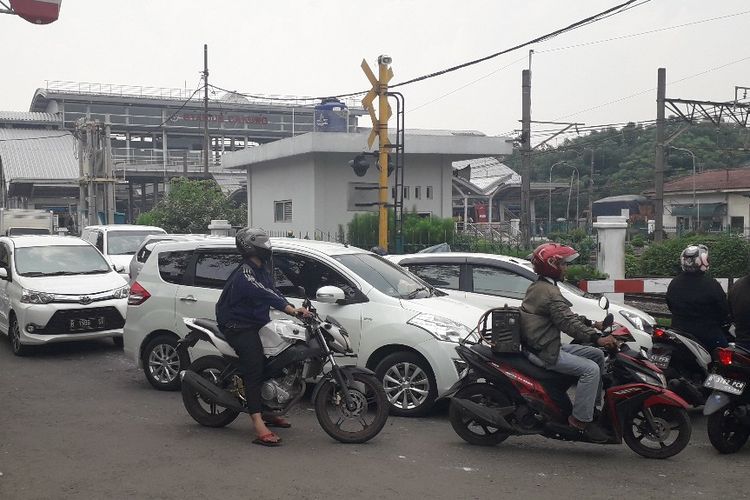 Antrean kendaraan menunggu dibukanya pelintasan KA di dekat Stasiun Cakung, Jakarta Timur, Rabu (10/4/2019).