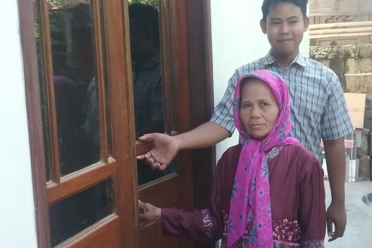 Siti Zanah, bersama anaknya Achmad Efendi, saat akan masuk rumah barunya. 