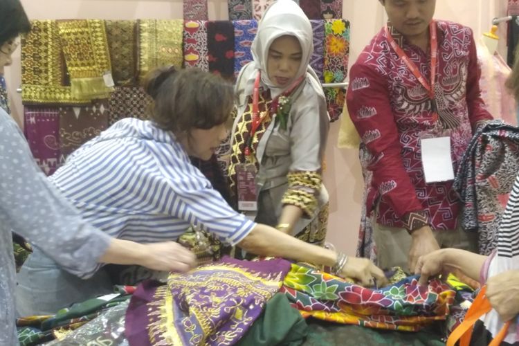 Nurbaiti saat melayani pembeli kain tapis Lampung dalam pameran Karya Kreatif Indonesia 2018 di JCC, Jakarta, Jumat (20/7/2018).