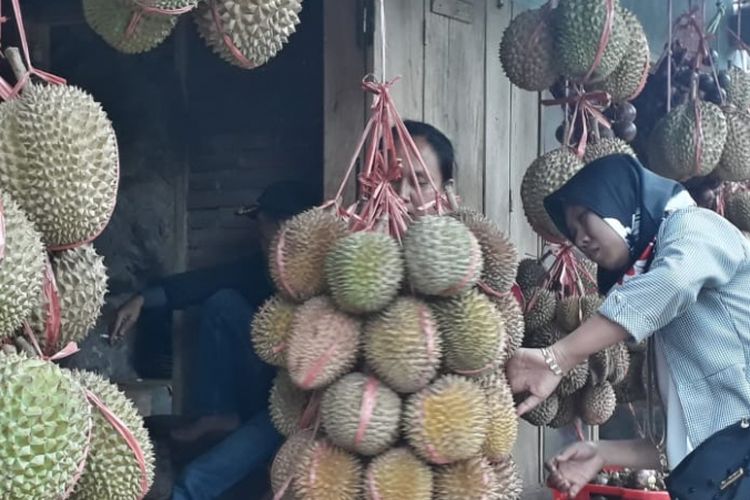 Pembeli memilih durian di pinggir jalur Pantura. Beli durian enaknya makan di tenpat. 