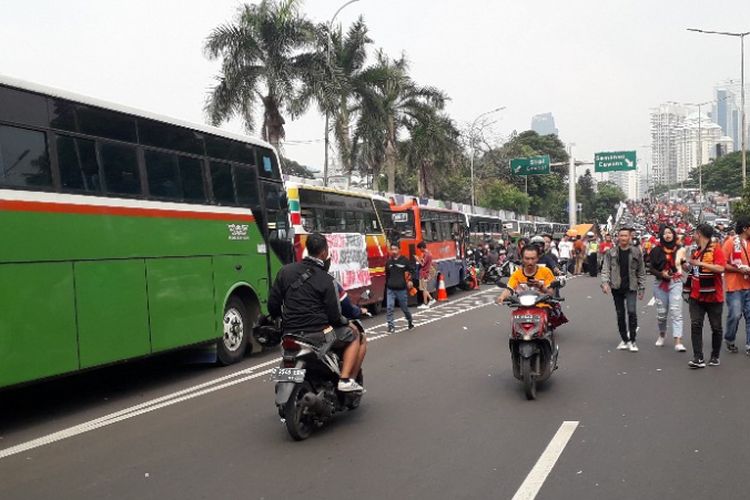 Bus-bus dan pejalan kaki mengokupasi Jalan Gerbang Pemuda, Senayan, jelang pertandingan Persija vs Mitra Kukar, Minggu (9/12/2018). 