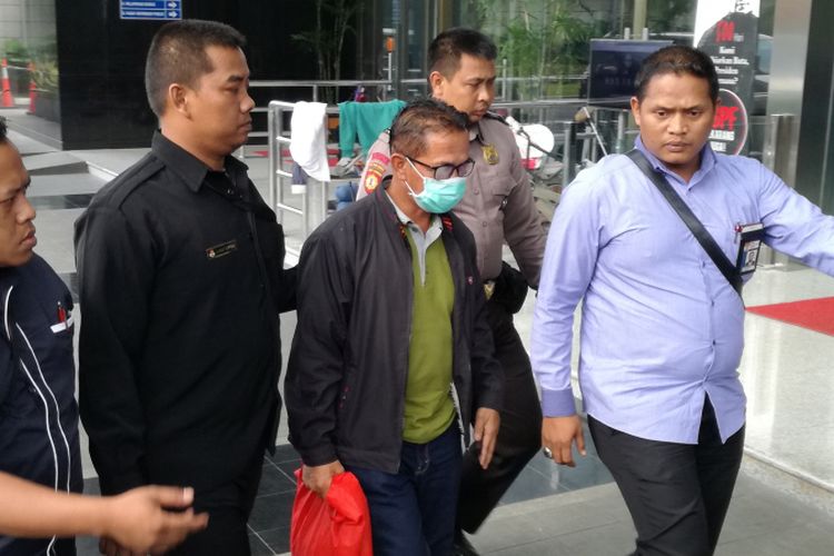 Bupati Mesuji Khamami (menggunakan masker) tiba di Gedung Merah Putih Komisi Pemberantasan Korupsi (KPK), Jakarta, Kamis (24/1/2019). Khamami tiba didampingi petugas KPK sekitar pukul 15.48 WIB.