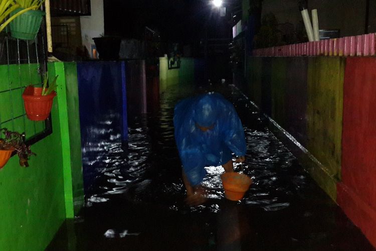 Warga membersihkan trotoar gang yang masih tergenang banjir di Jalan Kedawung gang 1 Kota Malang, Kamis (28/3/2019)
