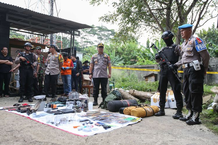 Polisi menunjukkan barang bukti di lokasi penangkapan terduga teroris di Kelurahan Nanggewer, Kecamatan Cibinong, Kabupaten Bogor, Jawa Barat, Sabtu (18/5/2019). Di lokasi ini polisi menangkap terduga teroris E alias AR (51).