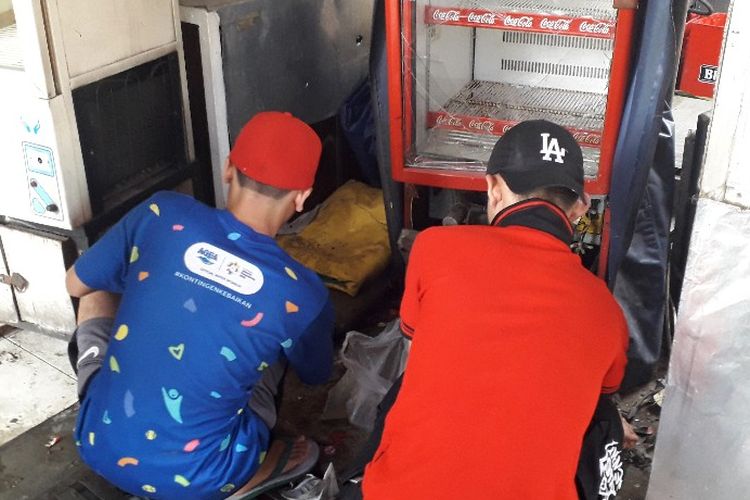 Dua orang karyawan warung rokok di Jalan KH Wahid Hasyim.membereskan sisa-sisa kerusakan di warung mereka, Kamis (23/5/2019).