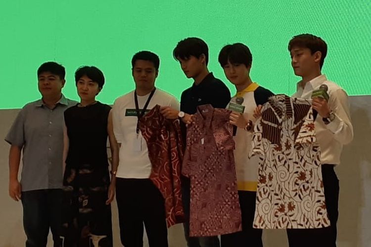 Tiga personel EXO, Kai (pakai kaos hitam), Suho (kaos putih berkerah kuning), dan Chen (kemeja putih lengan panjang) saat menerima batik dari perwakilan Nature Republic di Hotel Westin, Jakarta Selatan, Minggu (26/5/2019).