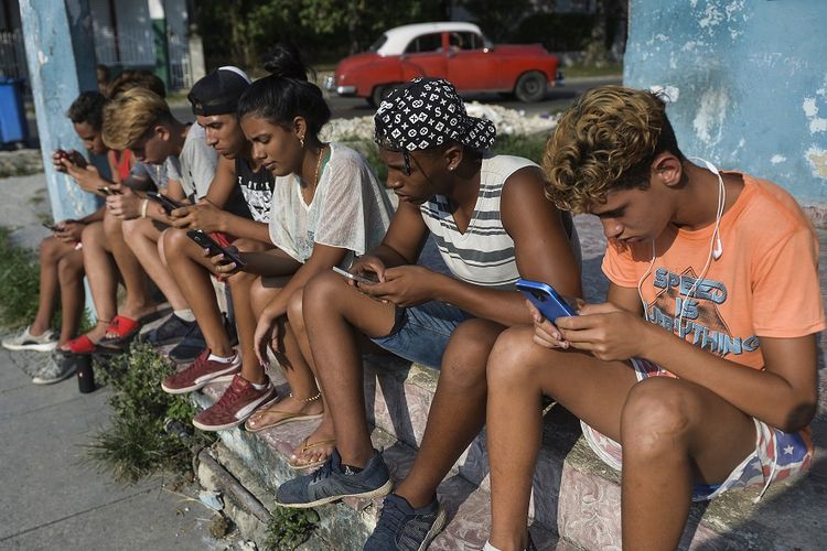 Kaum muda-mudi Kuba menggunakan ponsel pintar untuk akses internet yang dipandang masih sangat mahal di negara itu.
