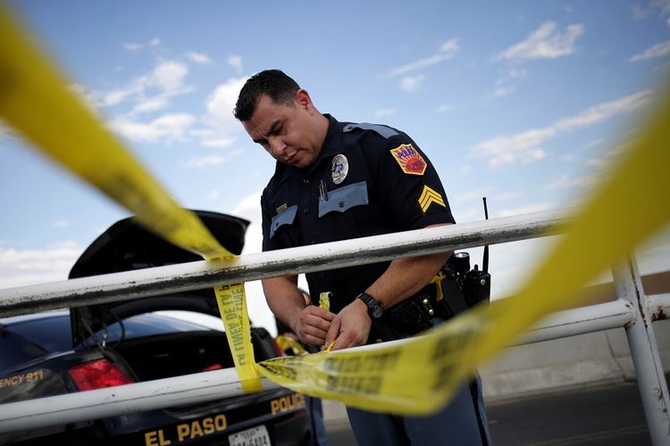 Polisi memasang garis  pembatas di sekitar toko Walmart di El Paso, Texas, di mana terjadi penembakan massal dengan korban sedikitnya 20 orang tewas, Sabtu (3/8/2019).