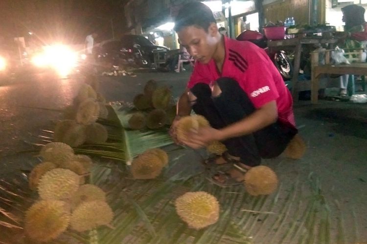 Pedagang memilihkan durian untuk pembeli di Jalan Perdagangan, Kota Lhokseumawe, Aceh, Sabtu (2/3/2019) malam.