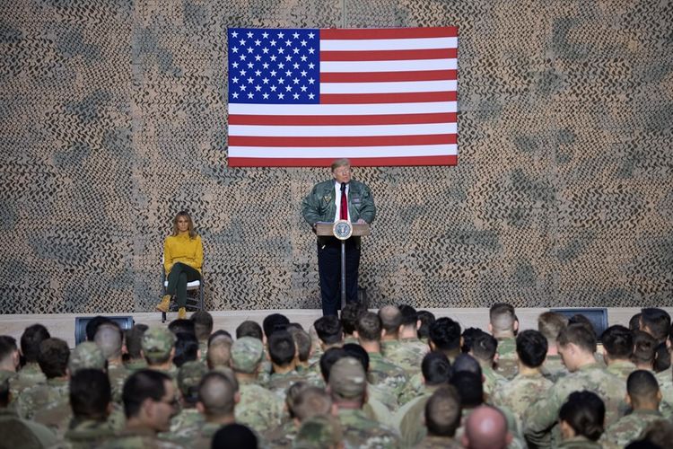 Presiden AS Donald Trump didampingi istrinya Melania menyampaikan pidato di hadapan pasukan AS di Pangkalan Udara Al-Asad di Irak, Rabu (26/12/2018).