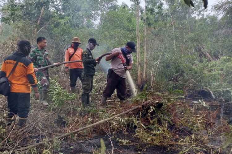 Petugas gabungan dari kepolisian, TNI dan Manggala Agni melakukan pemadaman api karhutla di Kelurahan Teluk Makmur, Kecamatan Medang Kampai, Kota Dumai, Riau, Senin (18/2/2019).