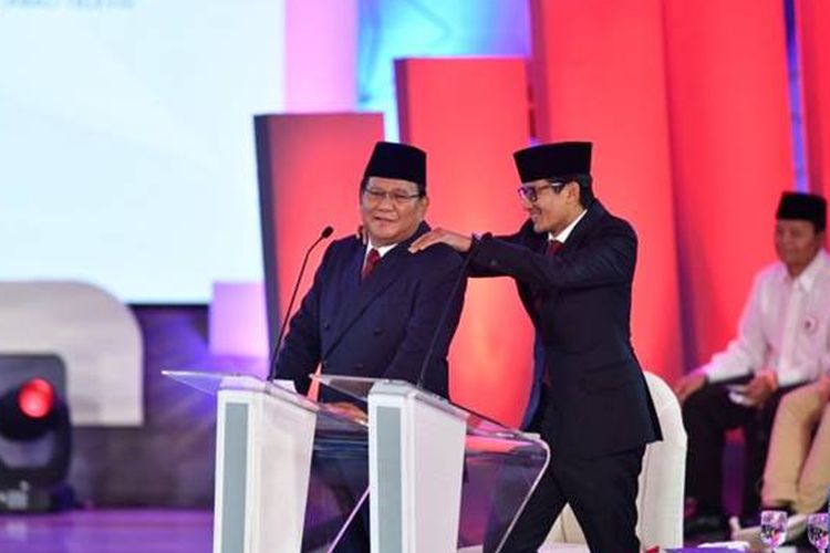 Sandiaga Uno memijat pundak Prabowo ketika ia ingin menanggapi pernyataan Jokowi.