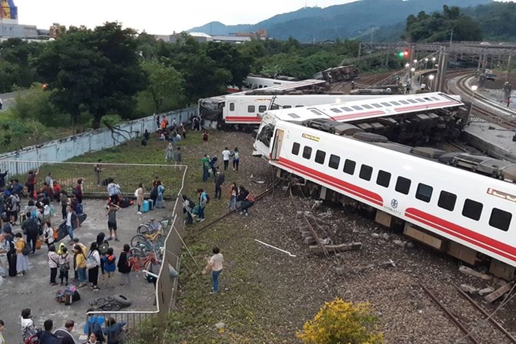 Warga melihat kondisi rangkaian kereta api yang terguling di Taiwan, Minggu (21/10/2018), dalam kecelakaan kereta api yang disebut terburuk sejak 20 tahun terakhir.