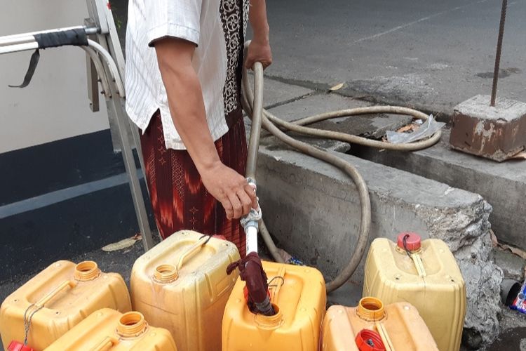 Saiful Anwar (40) sedang mengisi air PAM dalam dirigen sebab kelangkaan air bersih yang sudah melanda warga RW 09, Kelurahan Pegadungan, Kalideres, Jakarta Barat, Kamis (19/9/2019)