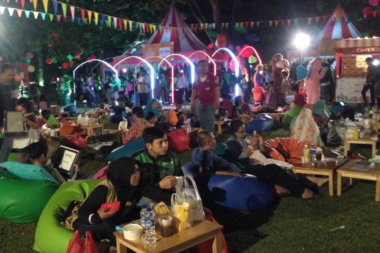 Ribuan mitra Go-Jek bersantai sambil menikmati makanan dalam acara Pasar Malam Hari Kuliner Nasional Go-Jek di Gelora Bung Karno, Senayan, Jakarta, Jumat (11/5/2018).