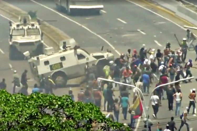 Kendaraan dari Garda Nasional Venezuela (GNB) menghantam kerumunan pendemo yang menggelar aksi protes di Caracas pada 30 April.