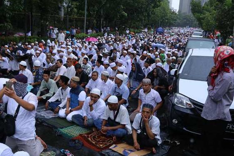 Ribuan pengunjuk rasa bersiap untuk melaksanakan ibadah shalat Jumat saat hujan turun pada Aksi 212 atau Doa Bersama pada 2 Desember 2016, di Jakarta, Jumat (2/12/2016). Selain mendoakan kesatuan Indonesia, massa juga mendesak pihak terkait agar segera menuntaskan kasus dugaan penistaan agama 