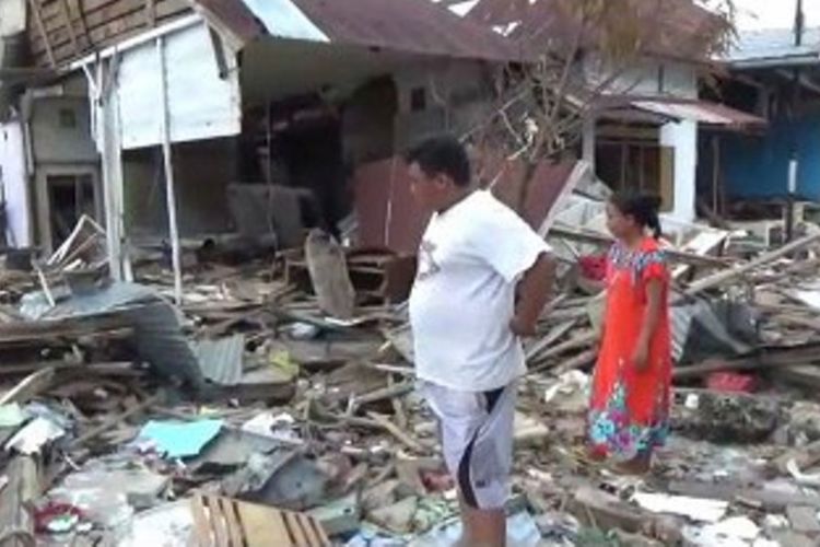 Gian dan istrinya melihat puing reruntuhan rumahnya yang rusak akibat gempa dan tsunami di Donggala