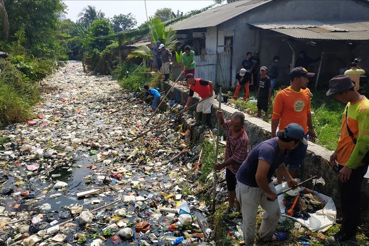 Warga bersama petugas dari koramil, kelurahan, dan Polsek Babelan membersihkan Kali Bahagia di Kabupaten Bekasi yang tertutup sampah, Selasa (30/7/2019). Mereka menggunakan peralatan sederhana.