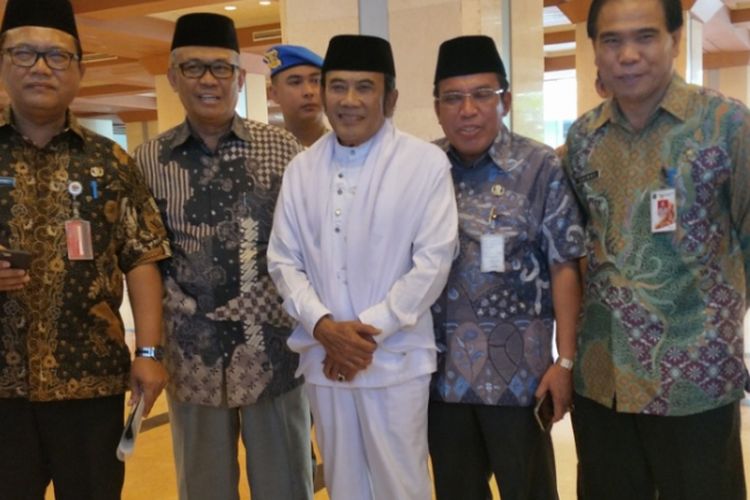 Rhoma Irama didampingi Kepala Biro Pendidikan Mental dan Spiritual DKI Jakarta Hendra Hidayat dan pejabat DKI lainnya keluar dari gedung Blok G Balai Kota, Kamis (7/12/2017).