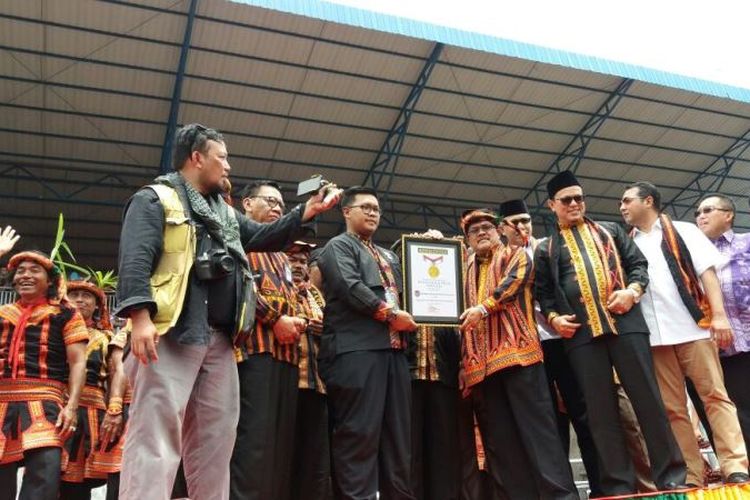 Manager MURI, Andre Purwandono saat menyerahkan Piagam Penghargaan Rekor Dunia Tari Saman terbanyak kepada Bupati Gayo Lues, Ibnu Hasyim, atas Pagelaran Saman 10001 Penari yang dilaksanakan di Stadion Seribu Bukit, Minggu (13/8/2017).
